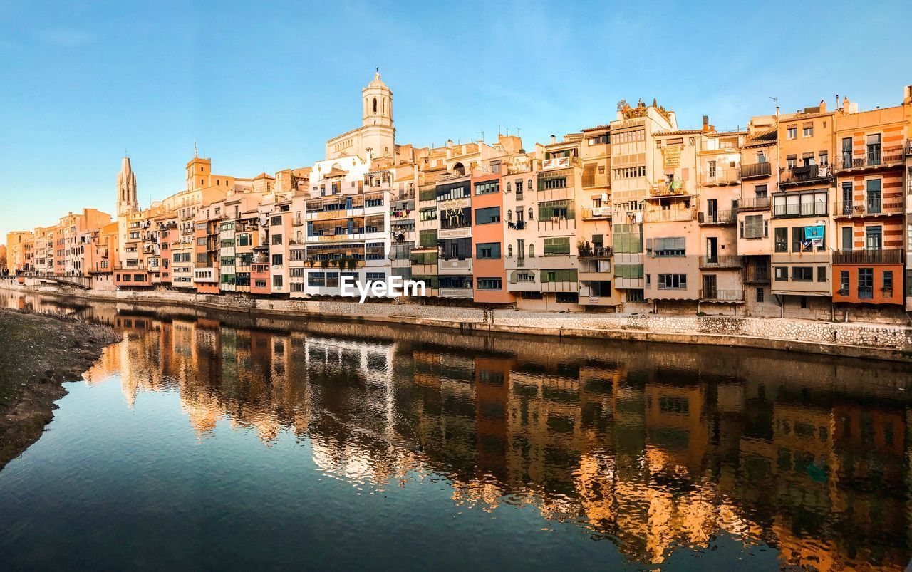 Reflection of buildings in river against sky