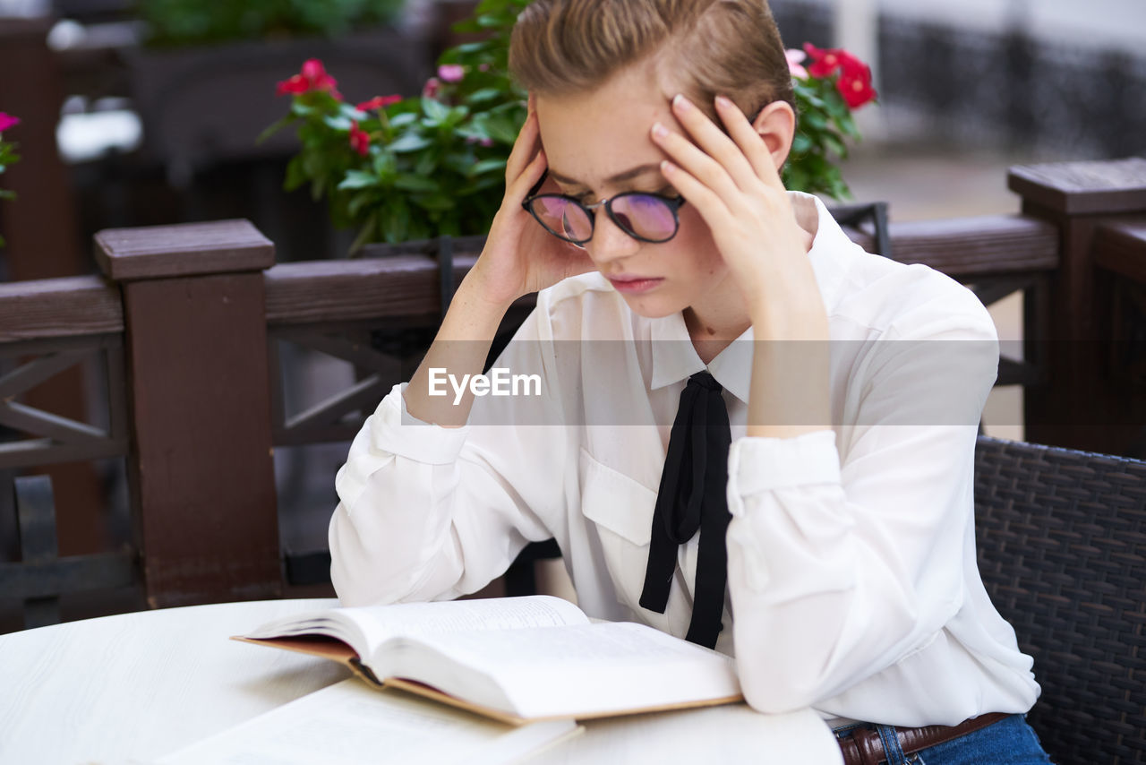 FULL LENGTH OF BOY SITTING ON TABLE WITH BOOK