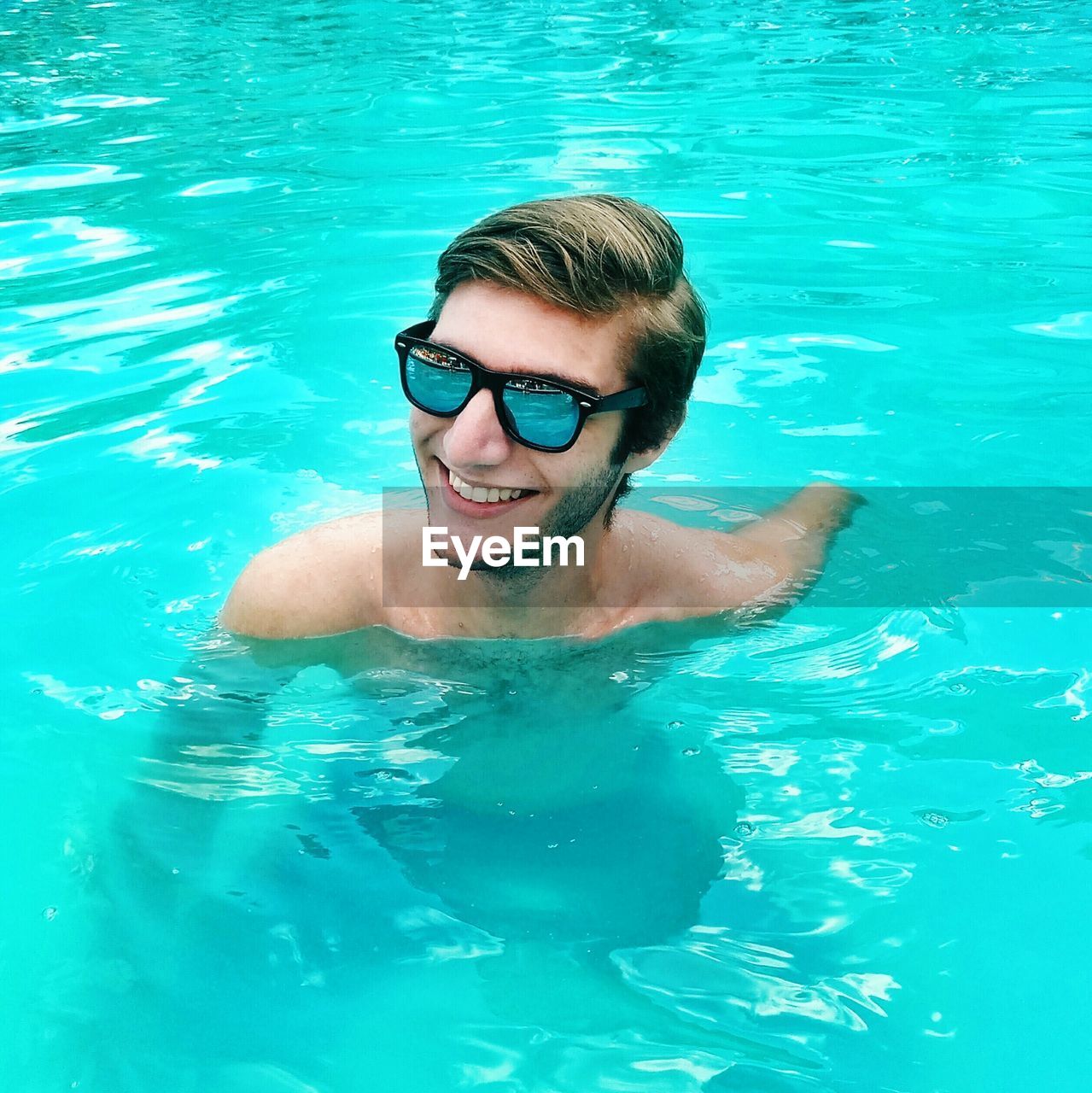 Smiling young man swimming in pool