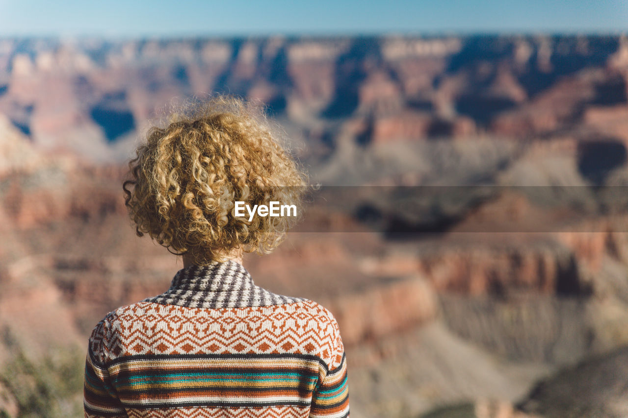 Rear view of woman with curly hair against landscape at grand canyon national park