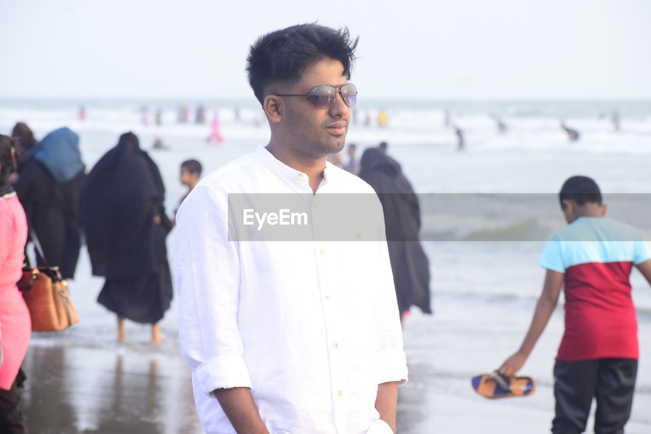 men, group of people, adult, water, focus on foreground, day, young adult, sea, walking, beach, black hair, casual clothing, nature, togetherness, outdoors, three quarter length, sports, leisure activity, clothing, standing, women, motion, looking, emotion, lifestyles, person, smiling, child, land, happiness, glasses