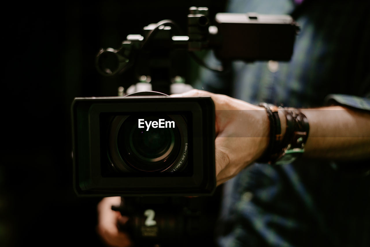 camera, technology, photographing, occupation, hand, adult, activity, one person, holding, photographer, digital slr, filming, close-up, film industry, professional occupation, lens - eye, photographic equipment, men, indoors, lens - optical instrument, arts culture and entertainment, expertise, selective focus