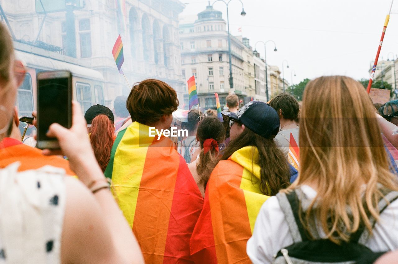 REAR VIEW OF PEOPLE PHOTOGRAPHING AT CITY