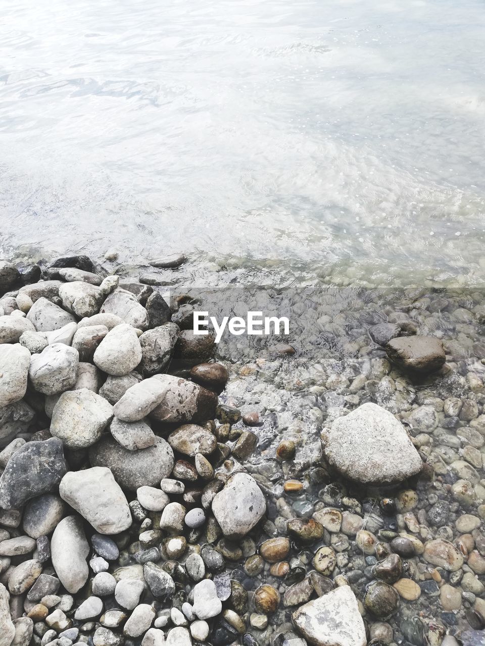 HIGH ANGLE VIEW OF STONES ON SHORE