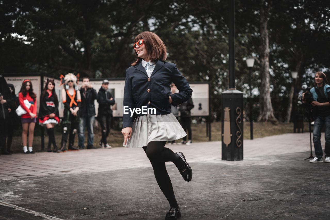 FULL LENGTH OF HAPPY WOMAN JUMPING IN TREES