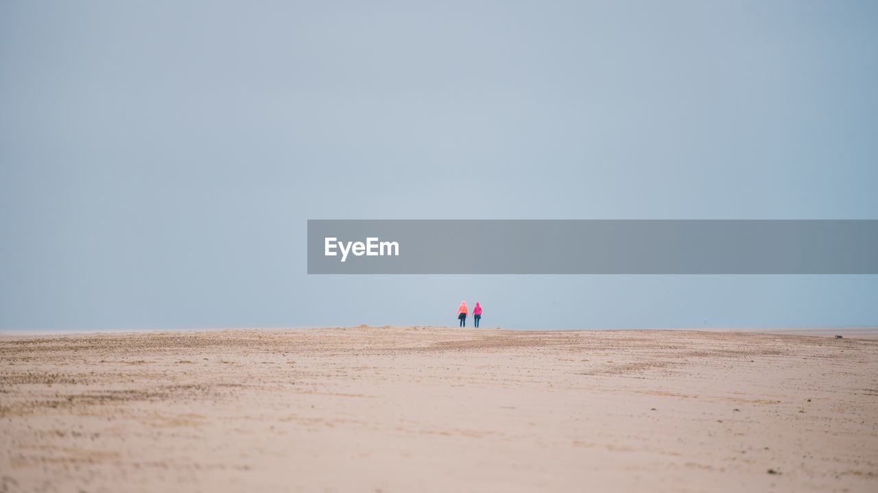 PEOPLE ON BEACH AGAINST SKY