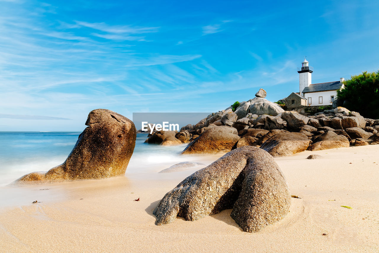 Scenic view of beach with the lighthouse of pontuvel, finistere, brittany, france