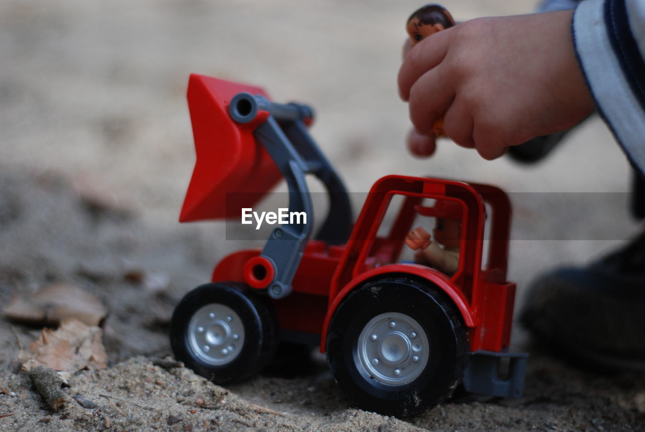 CLOSE-UP OF HAND WITH TOY CAR