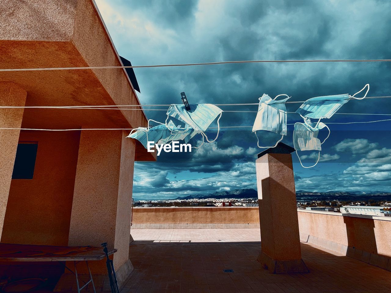 Masks drying on building against sky