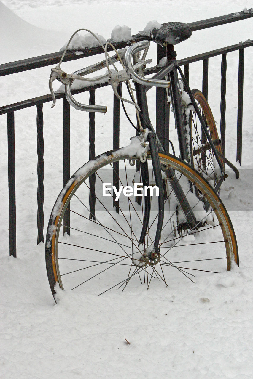 Frozen bicycle on snow during winter