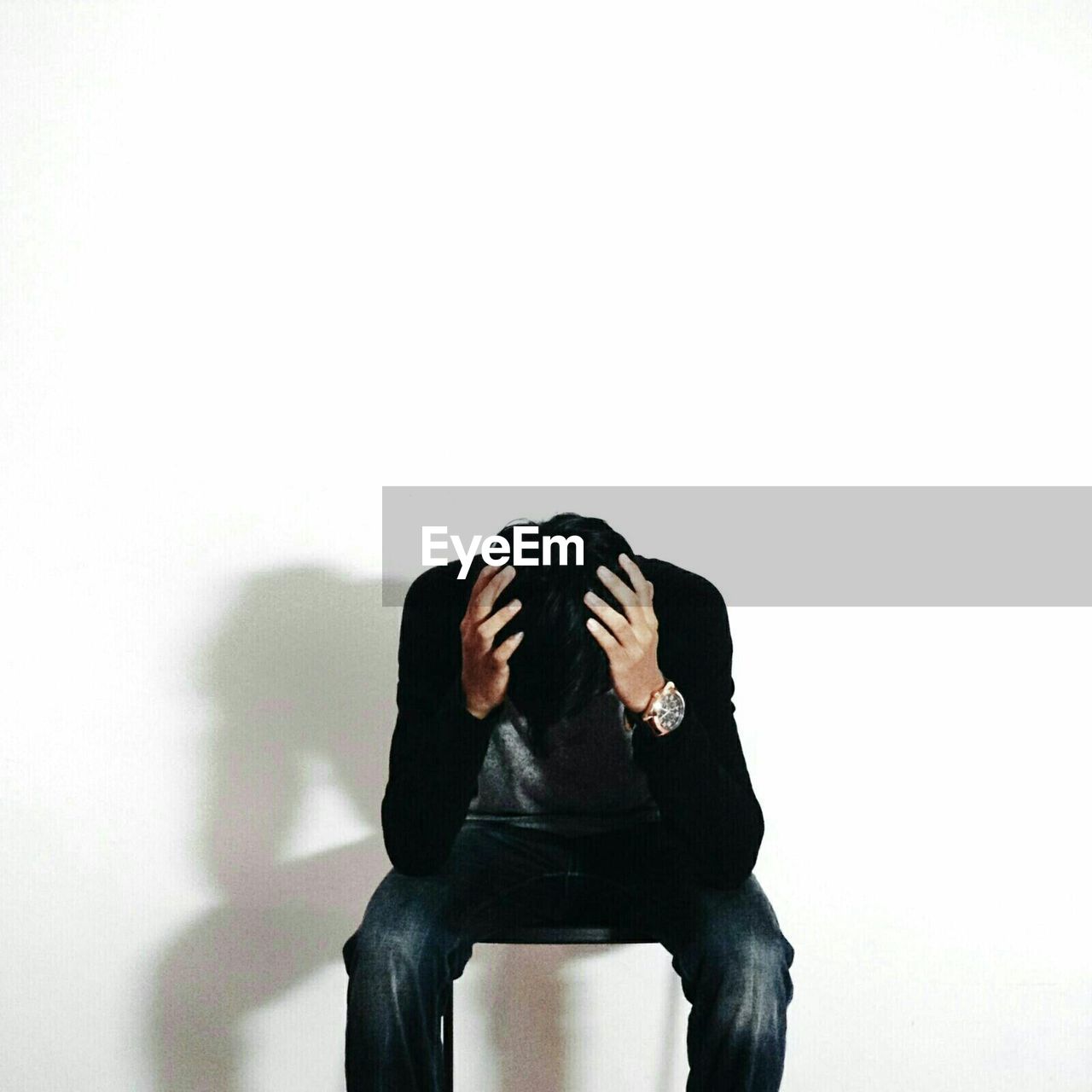 Depressed man sitting against white background