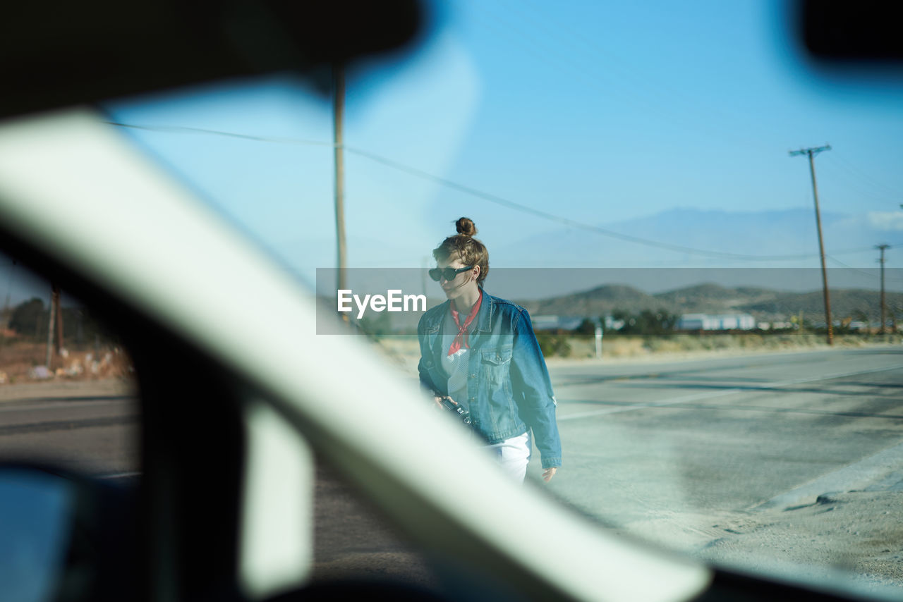 Woman seen through car window walking on street