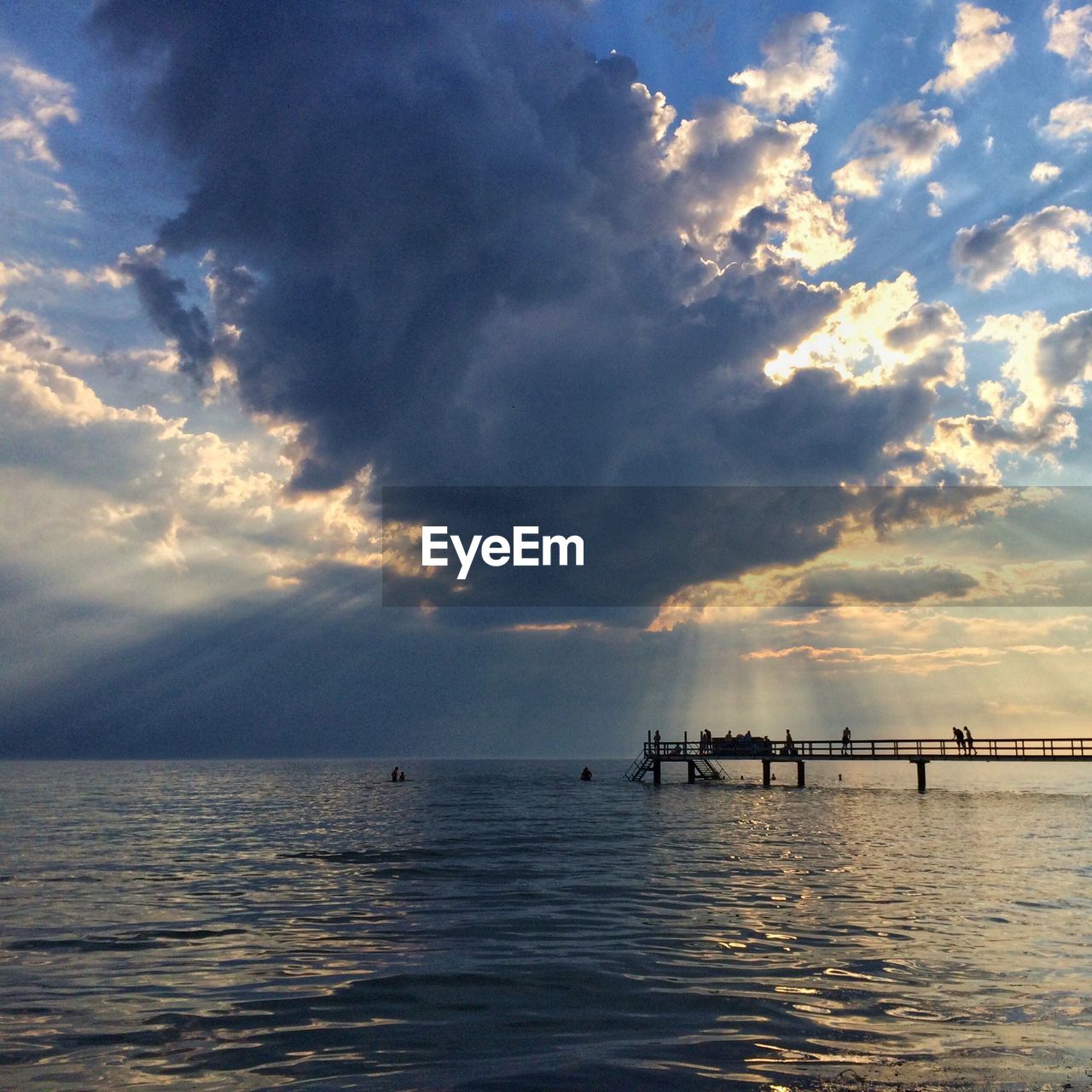 Pier amidst sea against cloudy sky