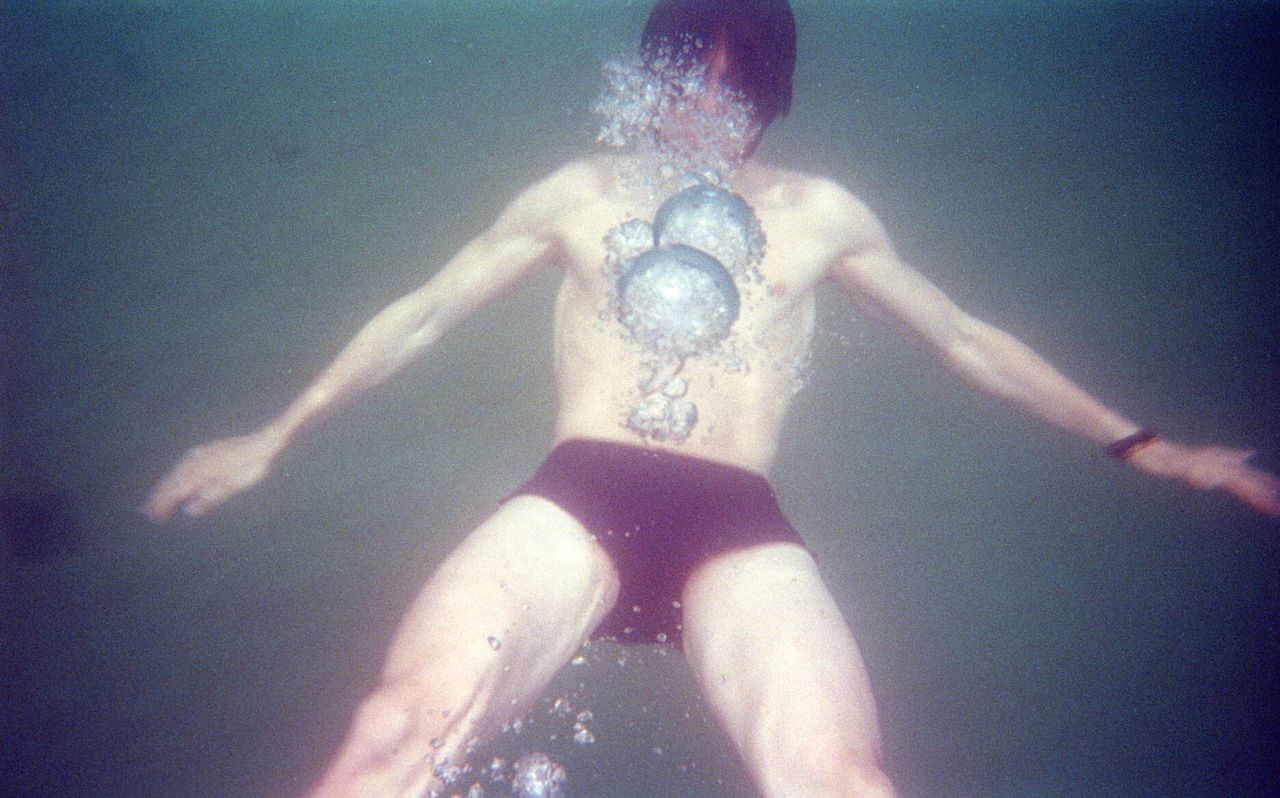 Shirtless young man swimming undersea