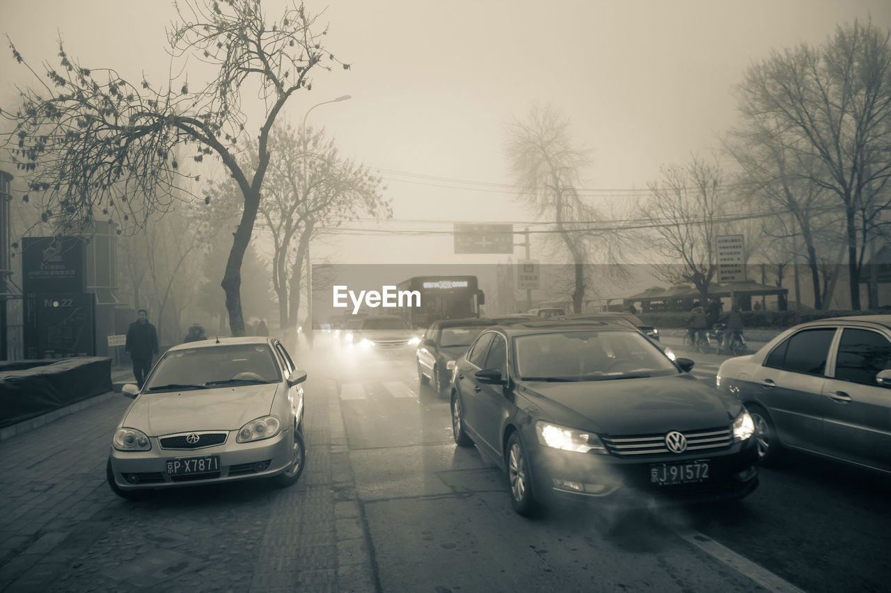 CARS ON STREET IN CITY AT DUSK