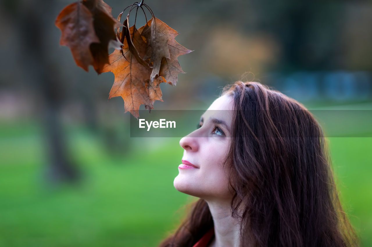 Close-up portrait of woman in autumn leaves