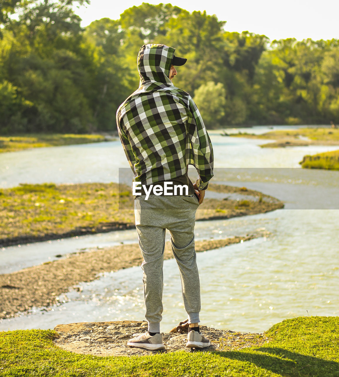 Rear view of man standing at riverbank