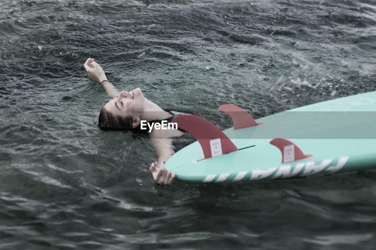 High angle view of smiling woman swimming in sea