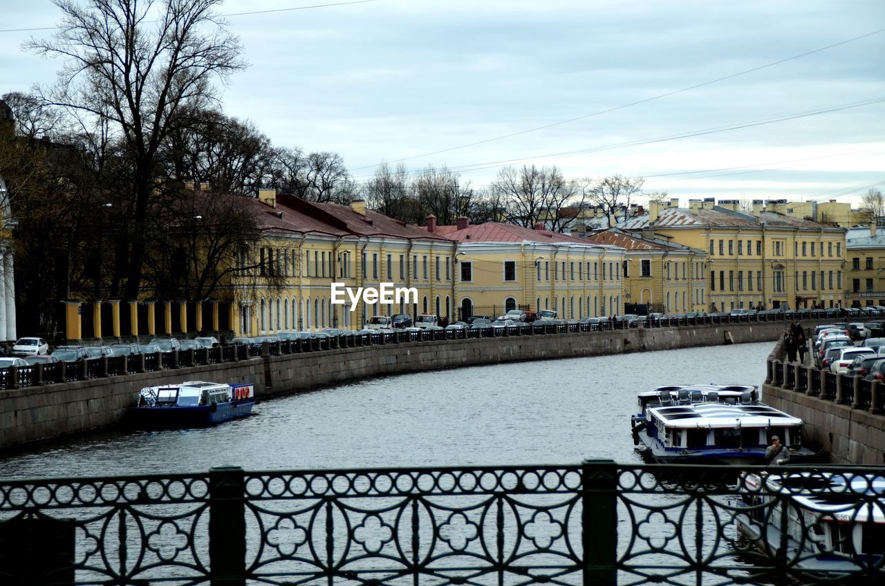 BOATS IN RIVER AGAINST SKY IN CITY