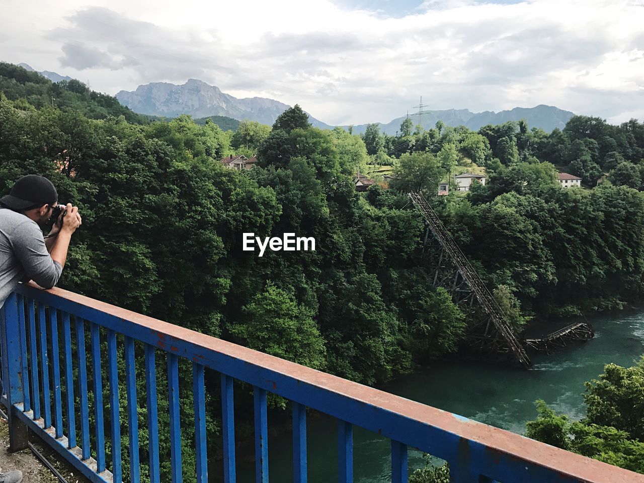 WOMAN BY RAILING AGAINST SKY