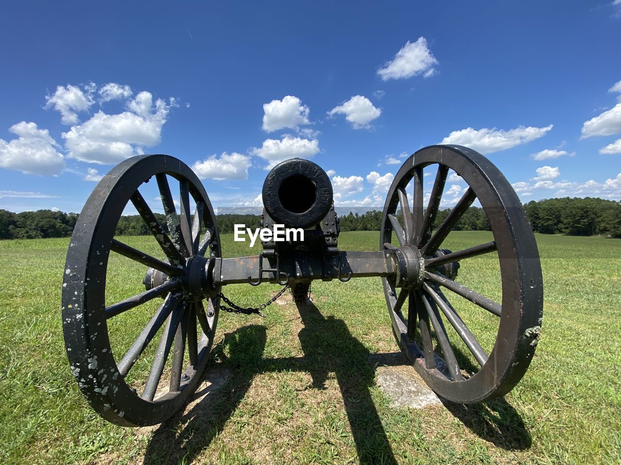 cannon, weapon, sky, fighting, conflict, war, history, the past, nature, cloud, grass, plant, wheel, landscape, land, field, no people, military, sunlight, day, transportation, vehicle, outdoors, scenics - nature, architecture, shadow, environment, green, rural scene, travel, old, battle