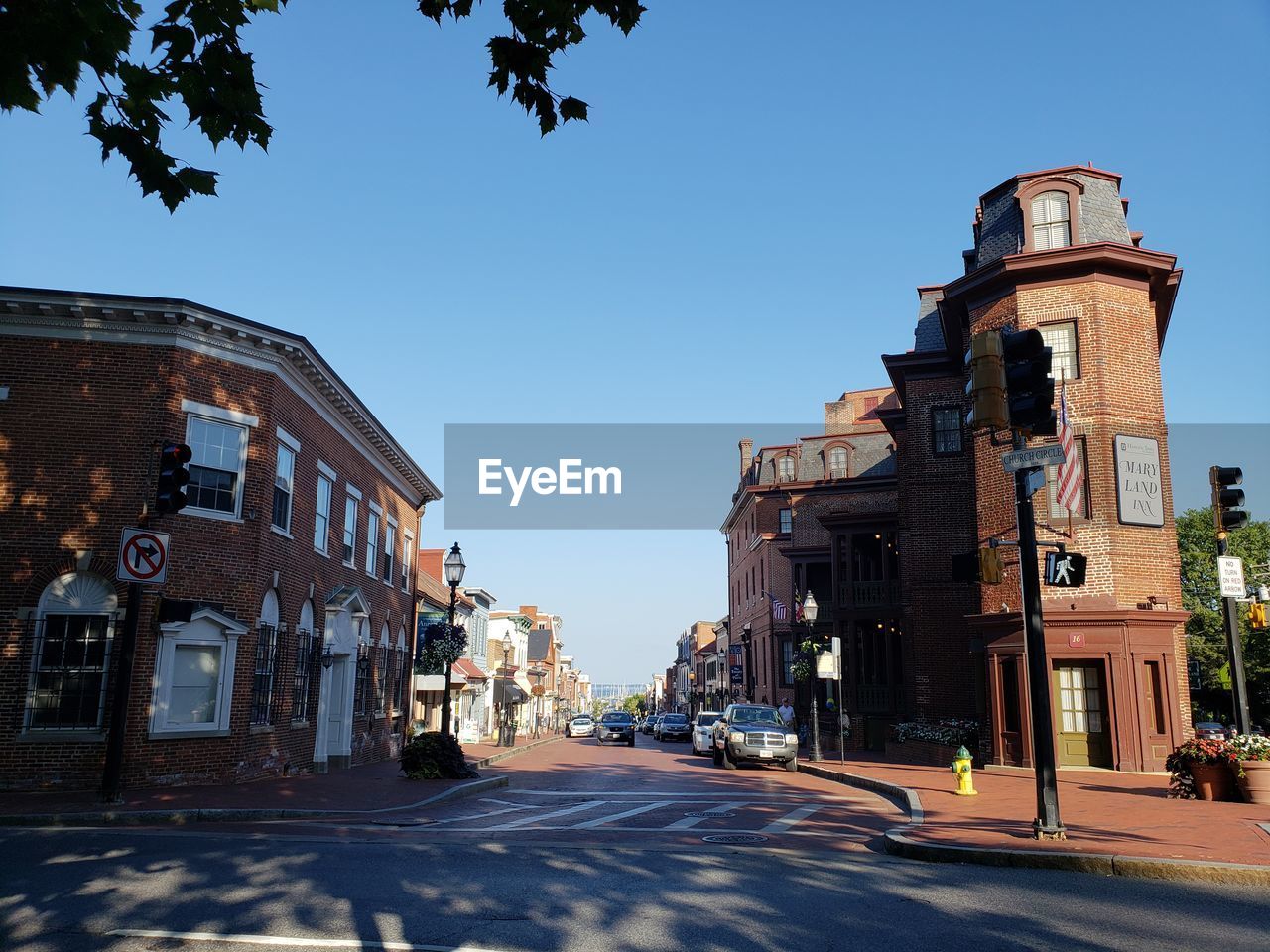 STREET AMIDST BUILDINGS AGAINST BLUE SKY