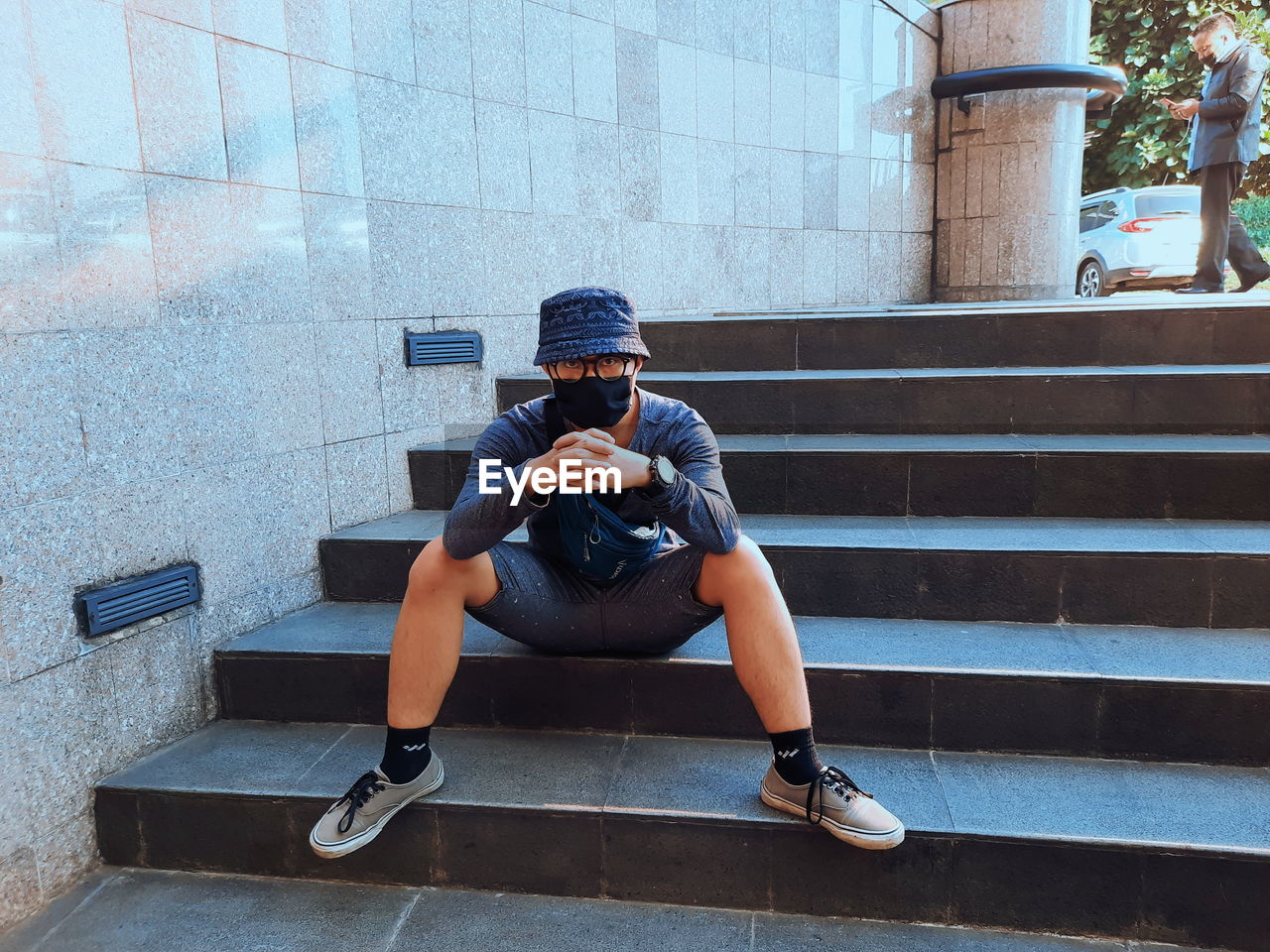 Full length of man sitting on staircase against building