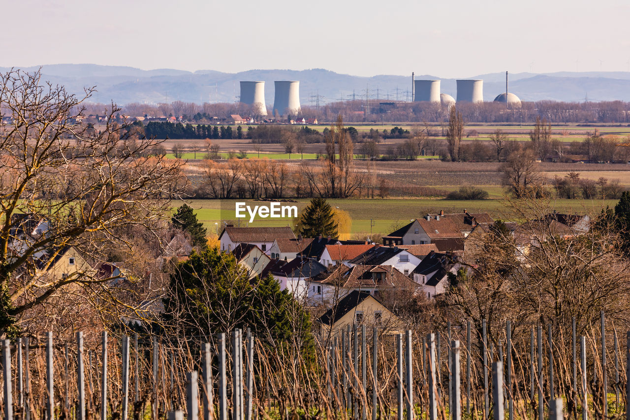 View of a nuclear power plant with houses and vineyards in the foreground