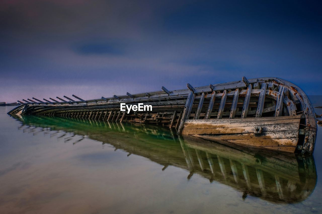 Abandoned boat in lake against sky