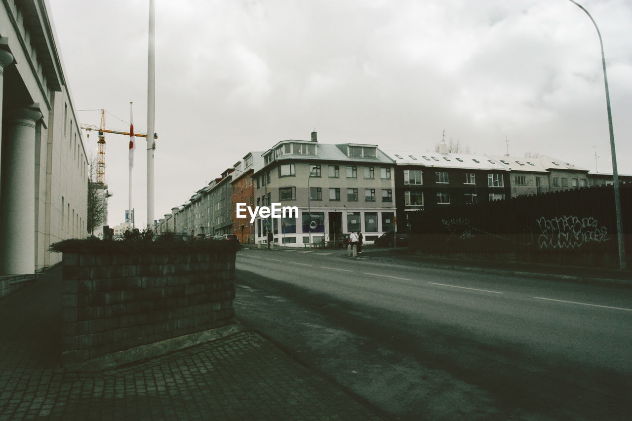 STREET AMIDST BUILDINGS AGAINST SKY