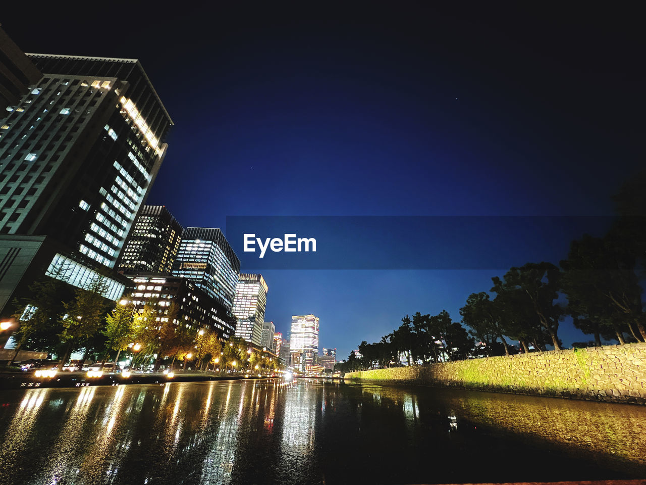 Low angle view of illuminated buildings against sky at night