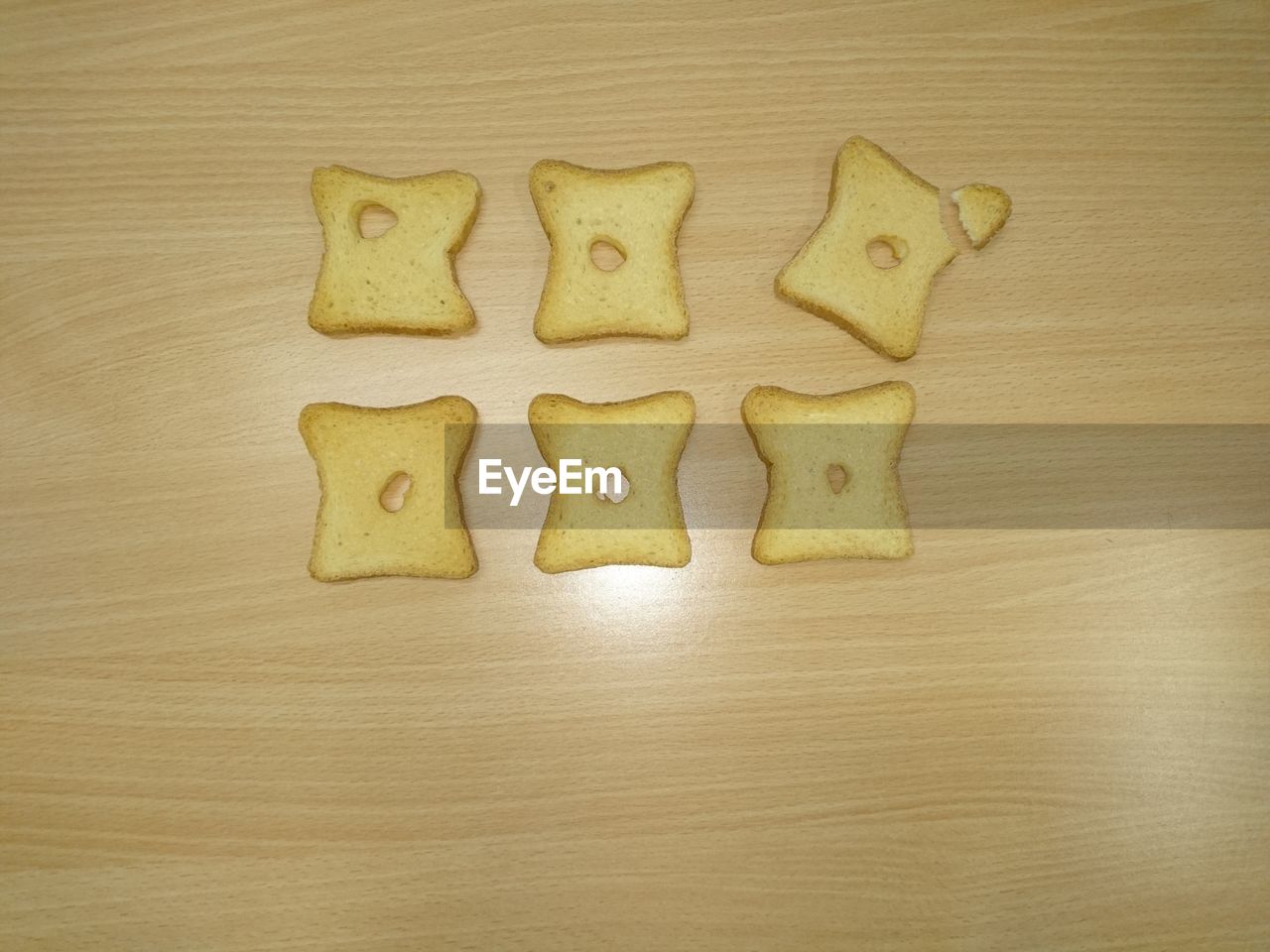 High angle view of holes in bread slices on table