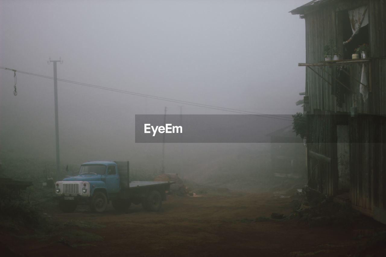 fog, morning, transportation, mode of transportation, land vehicle, mist, nature, architecture, haze, built structure, no people, building exterior, sky, motor vehicle, road, day, outdoors, car, city, cable, building, street