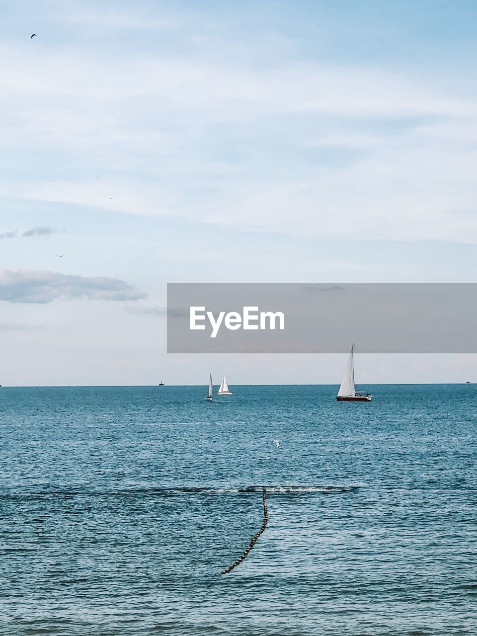 SAILBOAT ON SEA AGAINST SKY