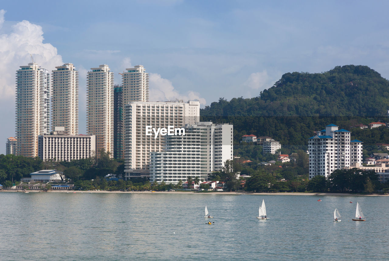 SEA BY BUILDINGS AGAINST SKY