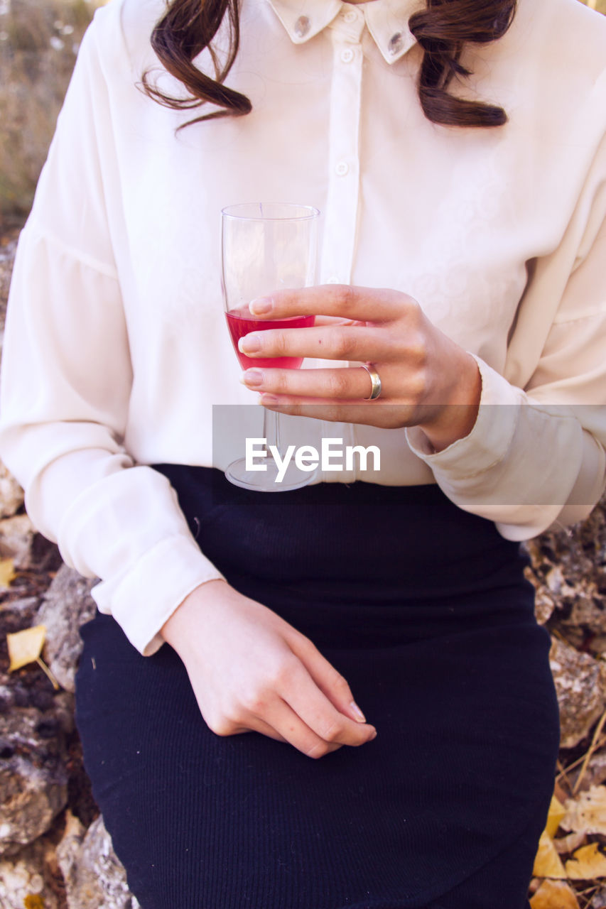 Midsection of woman holding drink