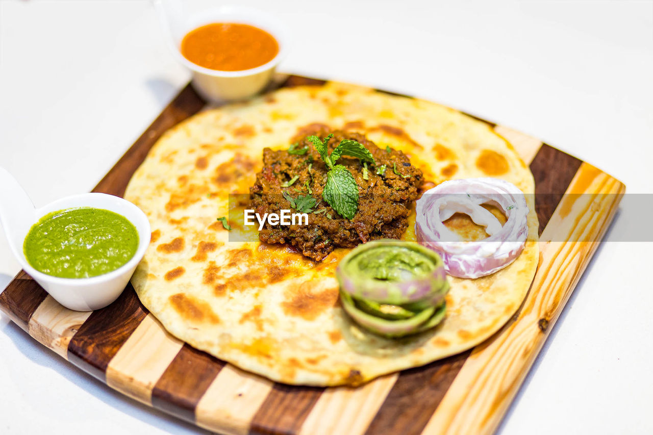 High angle view of fresh meal served on serving board against white background