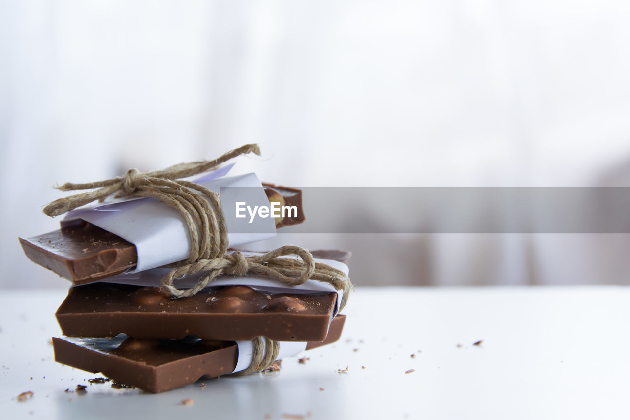 CLOSE-UP OF CHOCOLATE ON TABLE AGAINST WHITE BACKGROUND