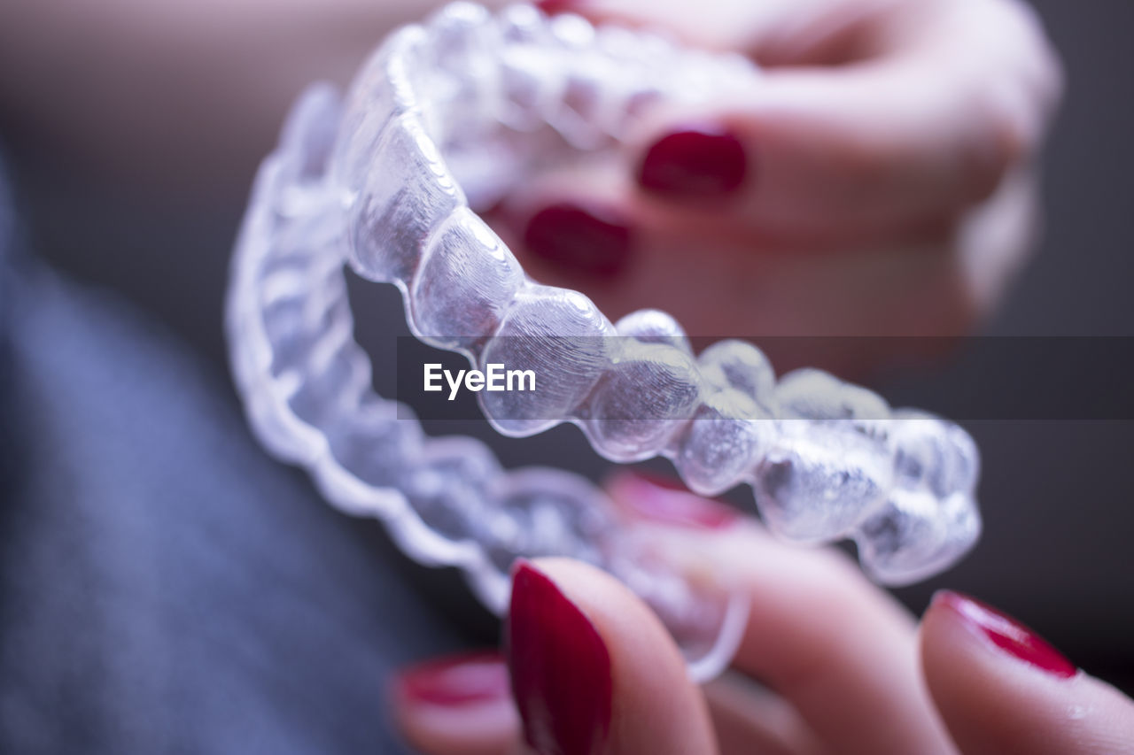 Cropped hand of woman holding artificial teeth