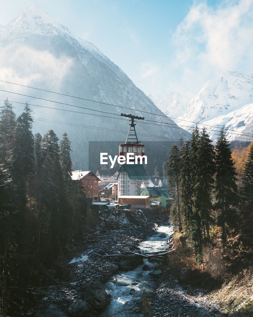 Buildings by mountain against sky during winter