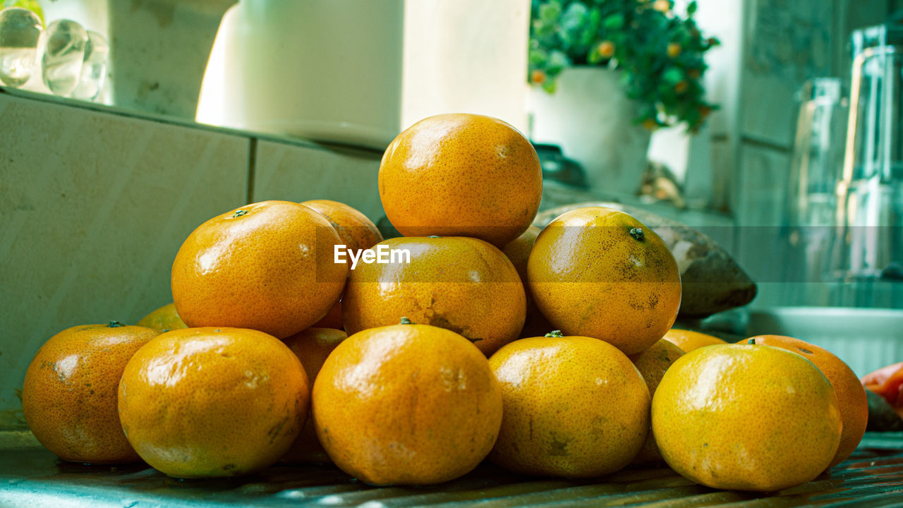 CLOSE-UP OF ORANGES ON TABLE