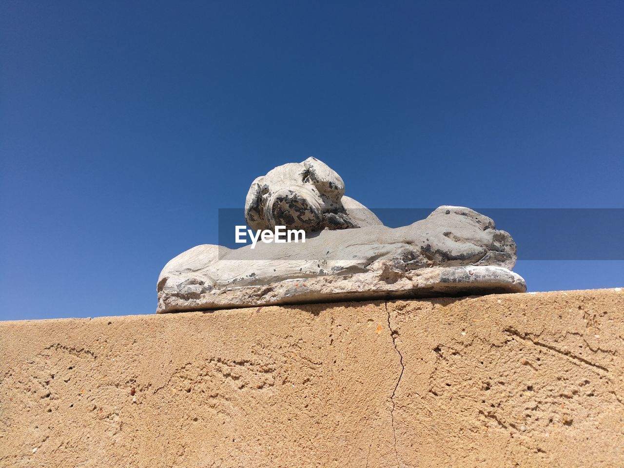 LOW ANGLE VIEW OF ROCK FORMATION AGAINST CLEAR BLUE SKY