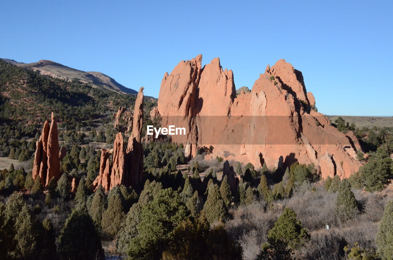 Panoramic view of rocky mountains against clear blue sky