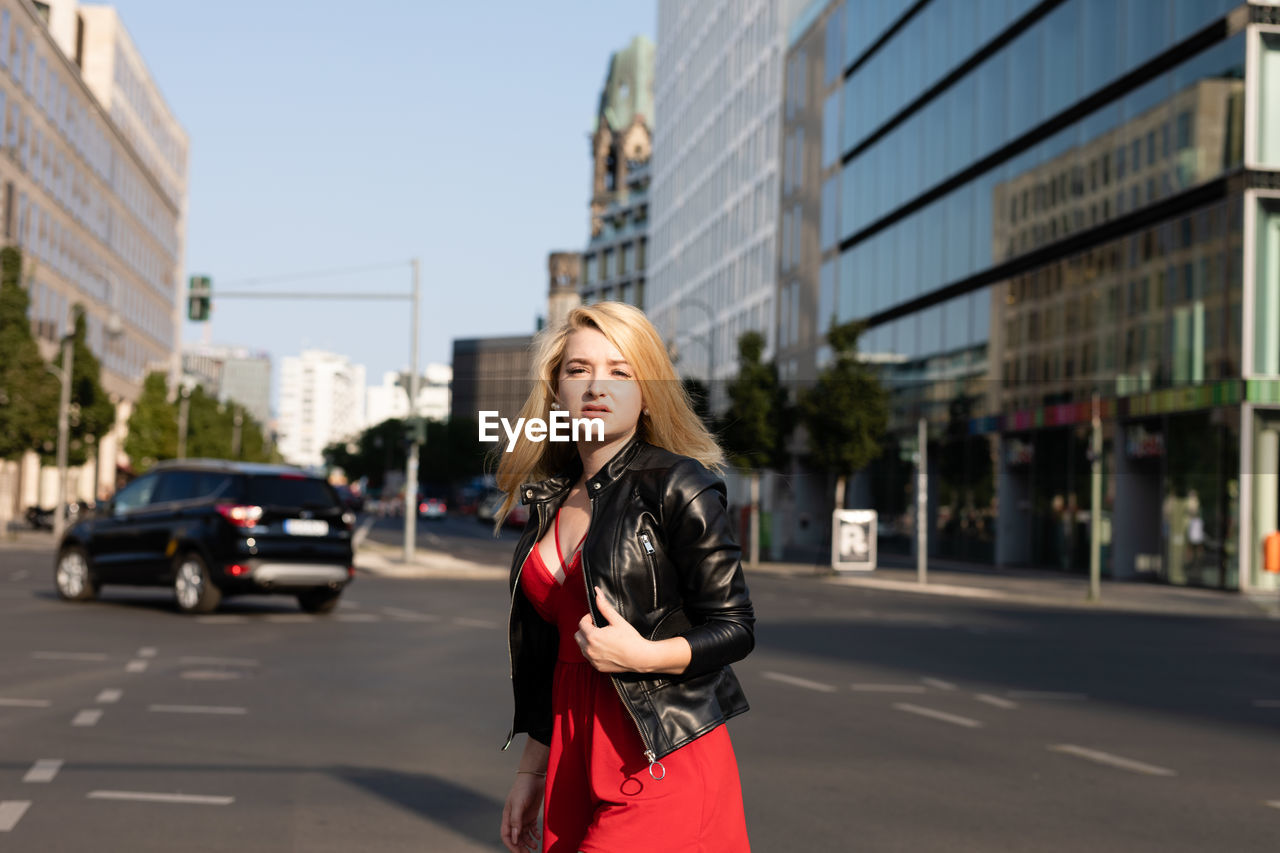 Portrait of woman standing on road in city