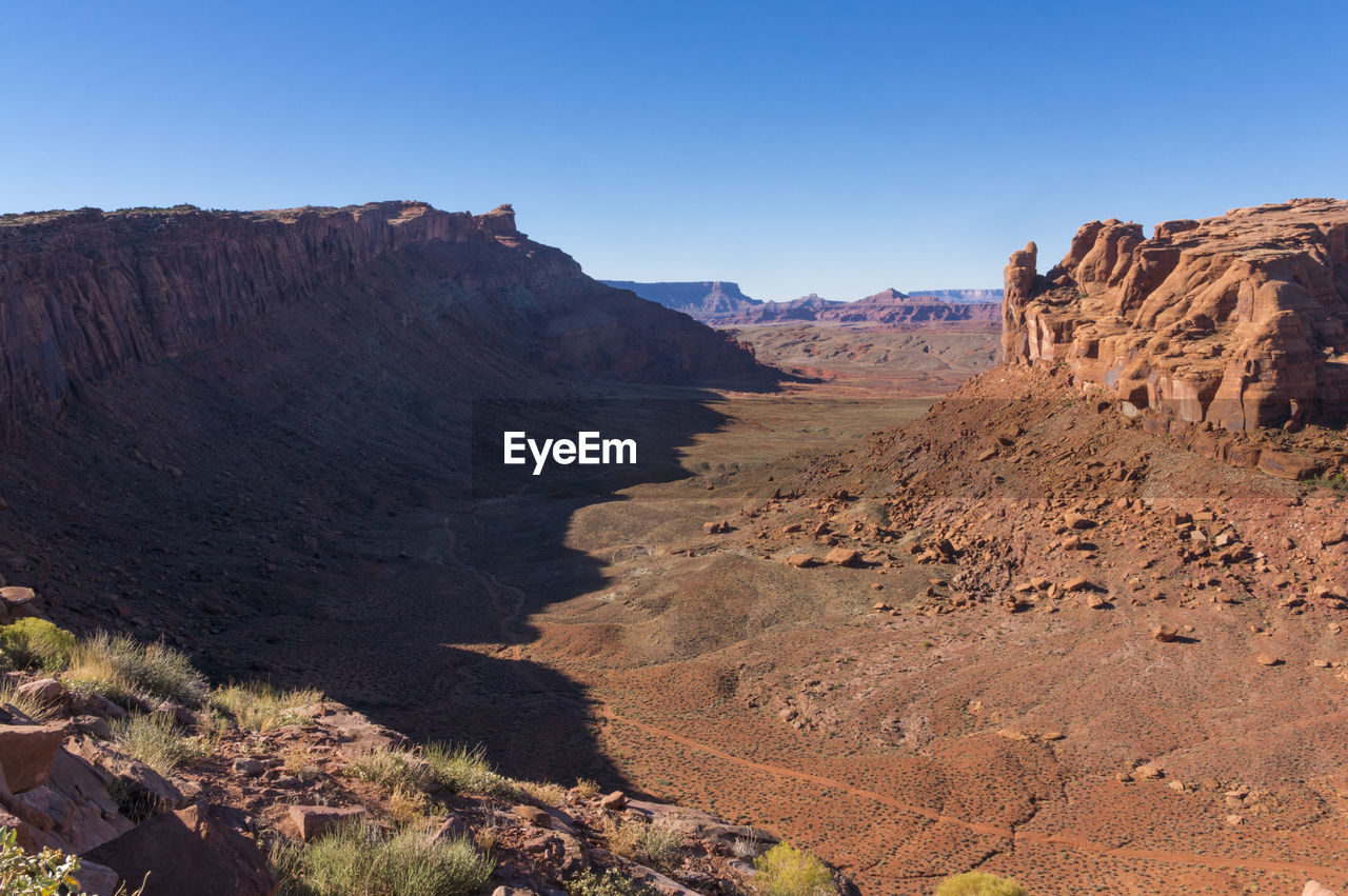 Scenic view of red rock against clear blue sky