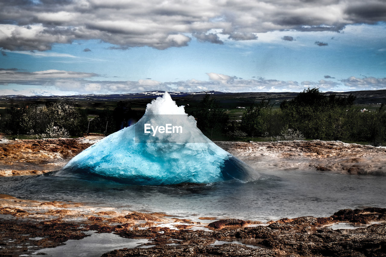 Scenic view of geyser erupting