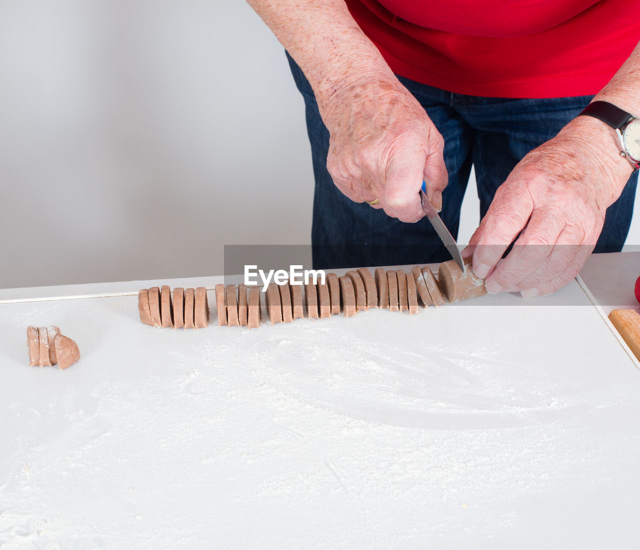 Midsection of man cutting cookies on table