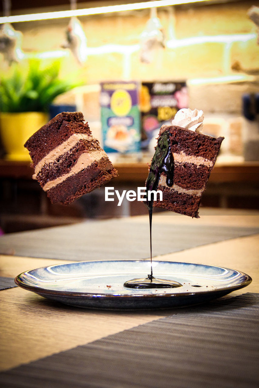 food and drink, food, sweetness, freshness, table, cake, dessert, sweet food, indoors, chocolate, no people, baked, sweet, meal, plate, wood, slice, icing, birthday cake, focus on foreground, temptation