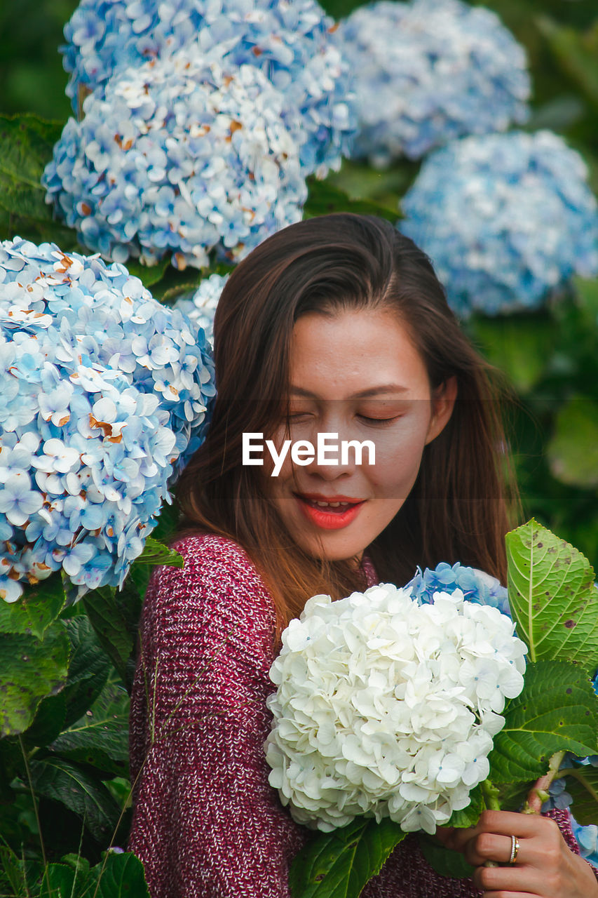 Smiling woman by flowering plants