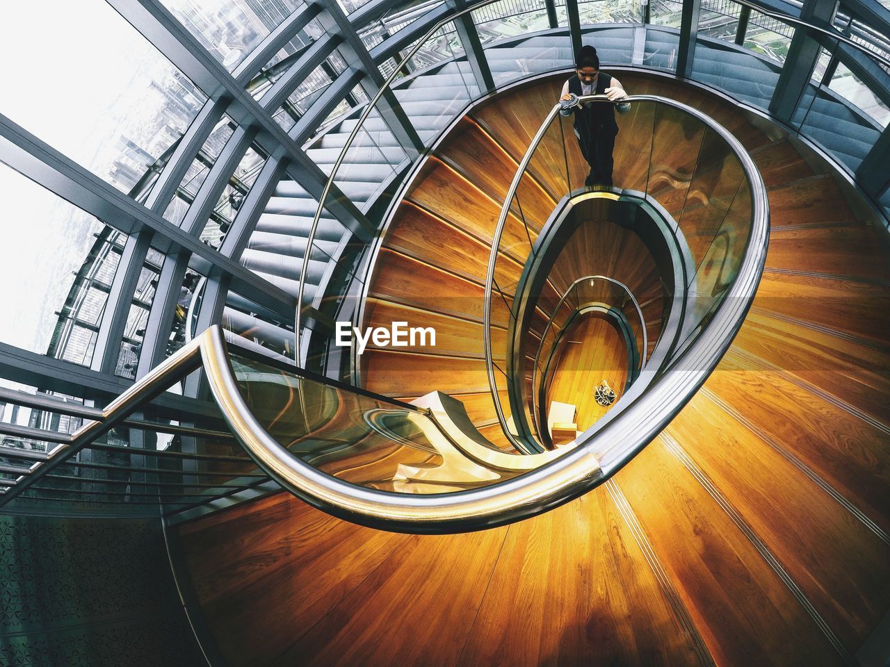 High angle view of woman standing on spiral staircase in building